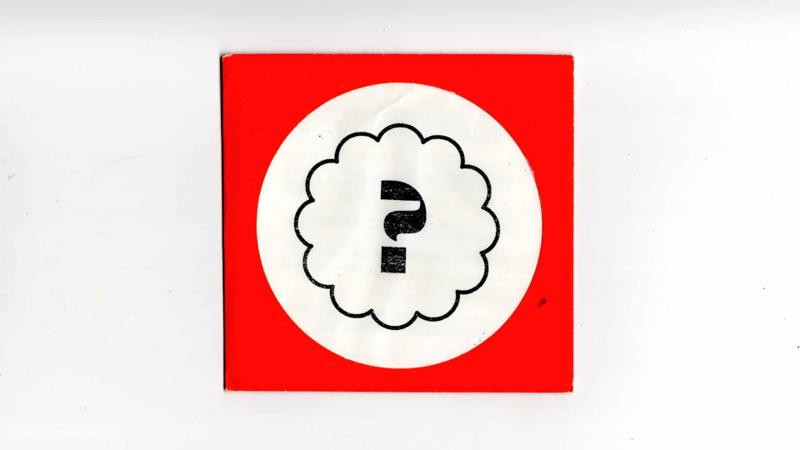 Scan of a red envelope, with a white circle and black question mark inside.